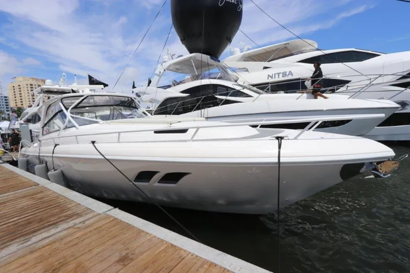Slide: The Image of 2019 Intrepid 475 Sport Yacht docked at marina, sleek design, white exterior. - 12