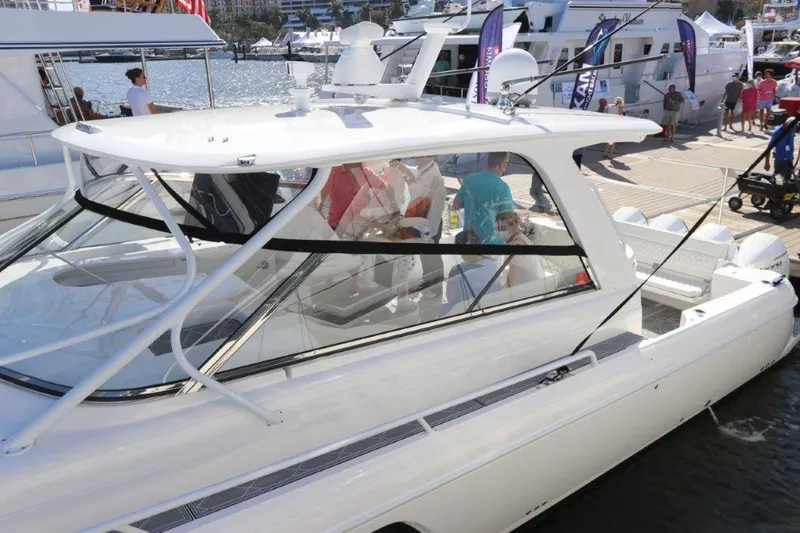 Slide: The Image of 2019 Intrepid 475 Sport Yacht docked at marina with people onboard. - 13