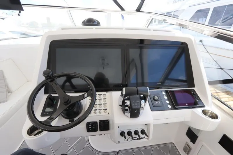Slide: The Image of 2019 Intrepid 475 Sport Yacht helm with dual screens and steering wheel. - 38