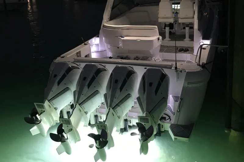 Slide: The Image of 2019 Intrepid 475 Sport Yacht with illuminated outboard motors at night. - 4