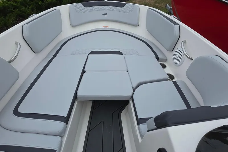 Slide: The Image of 2025 Bayliner M15 boat interior with gray cushioned seating and cup holders. - 15