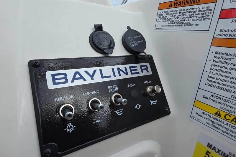 Slide: The Image of Control panel of 2025 Bayliner M15 boat with switches and warning labels. - 6