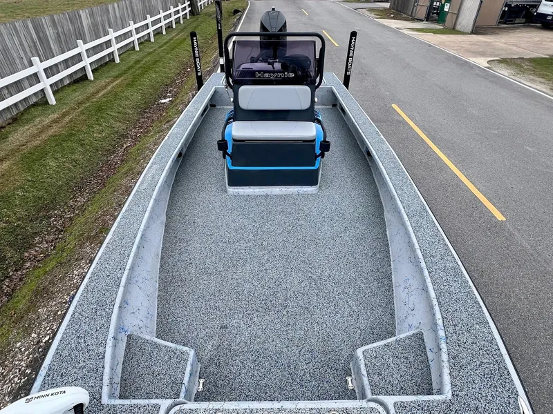 Slide: The Image of 2021 Haynie 25 Magnum boat on road, featuring spacious deck and seating. - 14