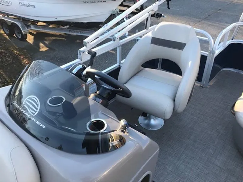 Slide: The Image of 2022 Sun Tracker PB 18 DLX pontoon boat interior with steering console and seating. - 12