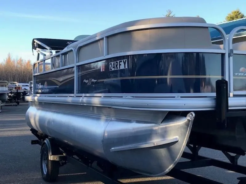 Slide: The Image of 2022 Sun Tracker PB 18 DLX pontoon boat on trailer in outdoor setting. - 2