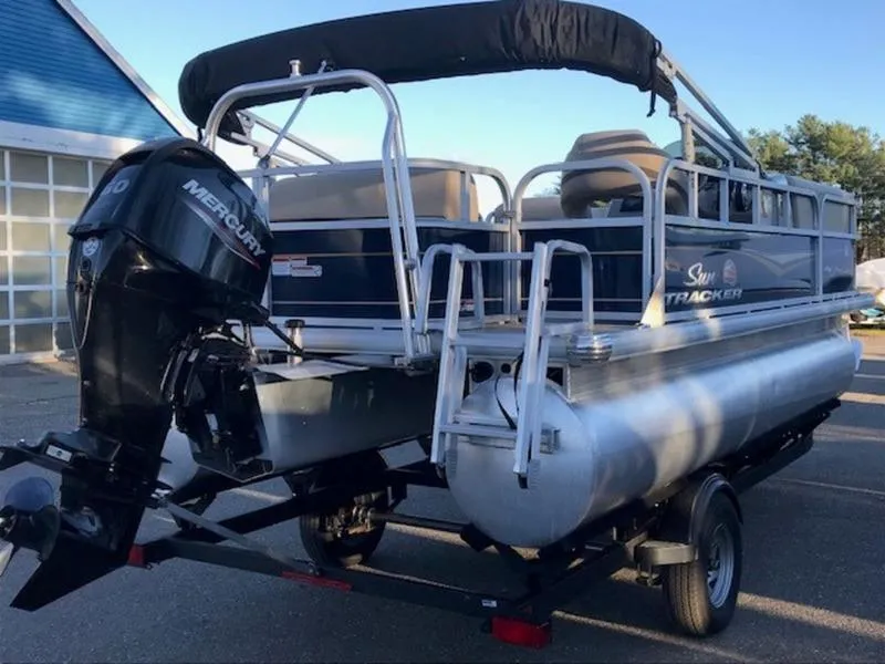 Slide: The Image of 2022 Sun Tracker PB 18 DLX pontoon boat with Mercury outboard motor on trailer. - 4