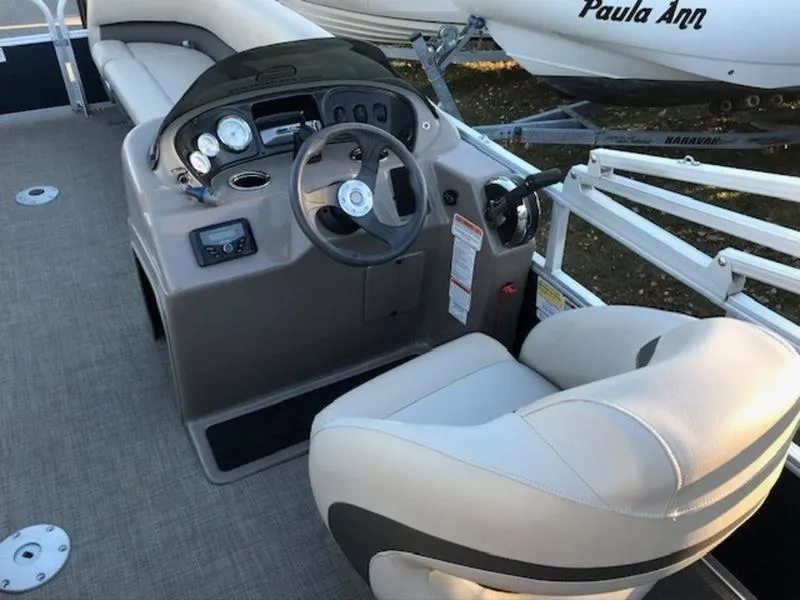 Slide: The Image of 2022 Sun Tracker PB 18 DLX boat interior with steering console and seating. - 9