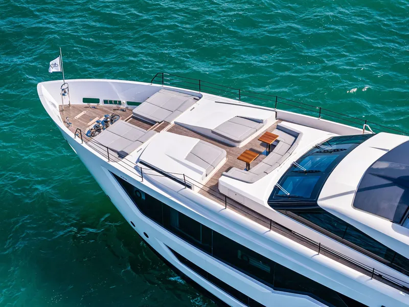 Slide: The Image of Luxurious 2022 Custom Line 106 yacht on turquoise water, featuring spacious sunbathing deck. - 10