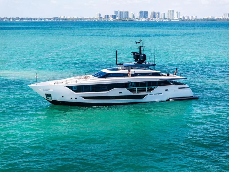 Slide: The Image of Luxurious 2022 Custom Line 106 yacht cruising in turquoise waters near a city skyline. - 16