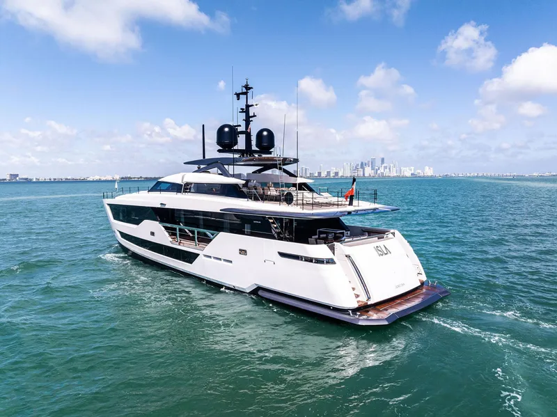 Slide: The Image of Luxury yacht Custom Line 106, 2022 model, cruising on open sea with city skyline backdrop. - 20