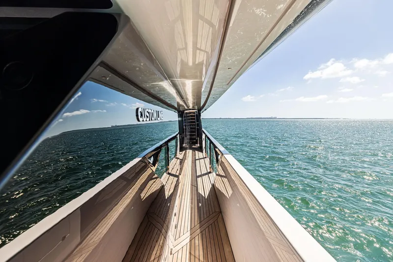 Slide: The Image of Custom Line 106 yacht deck, 2022 model, overlooking serene ocean waters. - 30