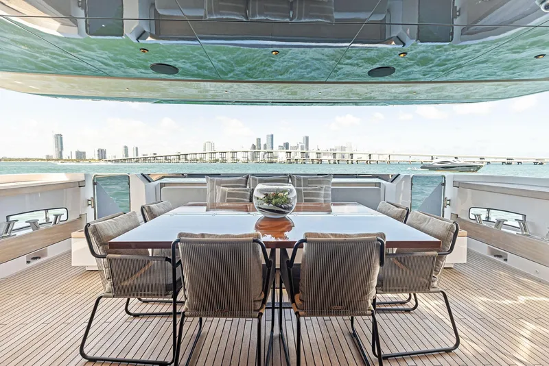 Slide: The Image of Luxury yacht deck with dining area, Custom Line 106, 2022 model, overlooking city skyline and ocean. - 34