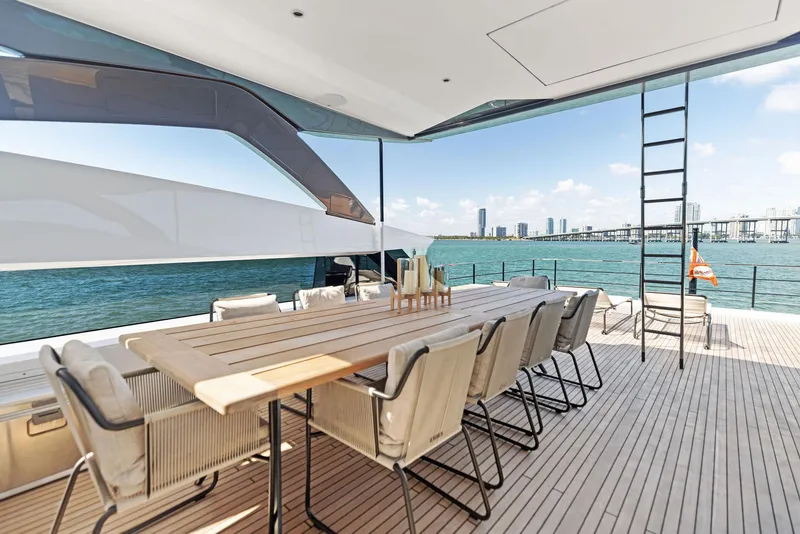 Slide: The Image of Luxurious Custom Line 106 yacht deck with dining area, overlooking ocean and city skyline, 2022 model. - 38