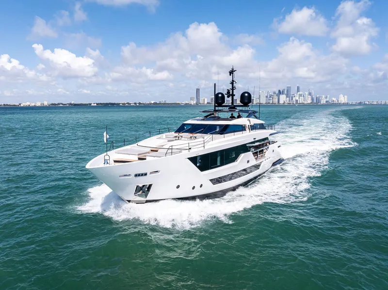 Slide: The Image of Luxurious 2022 Custom Line 106 yacht cruising on open sea with city skyline backdrop. - 4