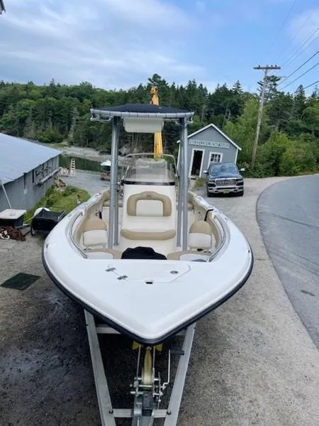 Slide: The Image of 2016 Key West 203FS boat on trailer, parked near rustic buildings and trees. - 3