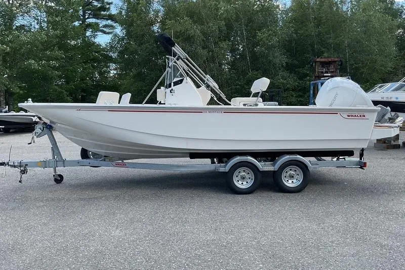 Slide: The Image of 2025 Boston Whaler 210 Montauk boat on trailer, parked outdoors. - 4