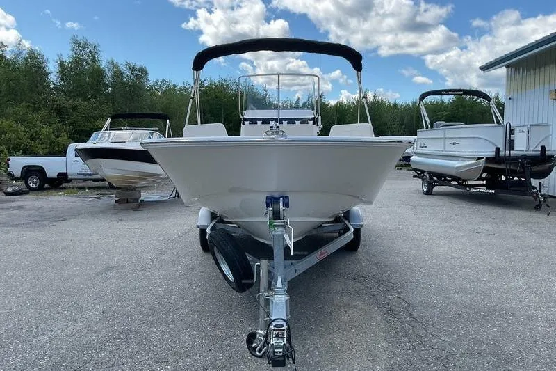 Slide: The Image of 2025 Boston Whaler 210 Montauk boat on trailer, parked outdoors under a cloudy sky. - 5