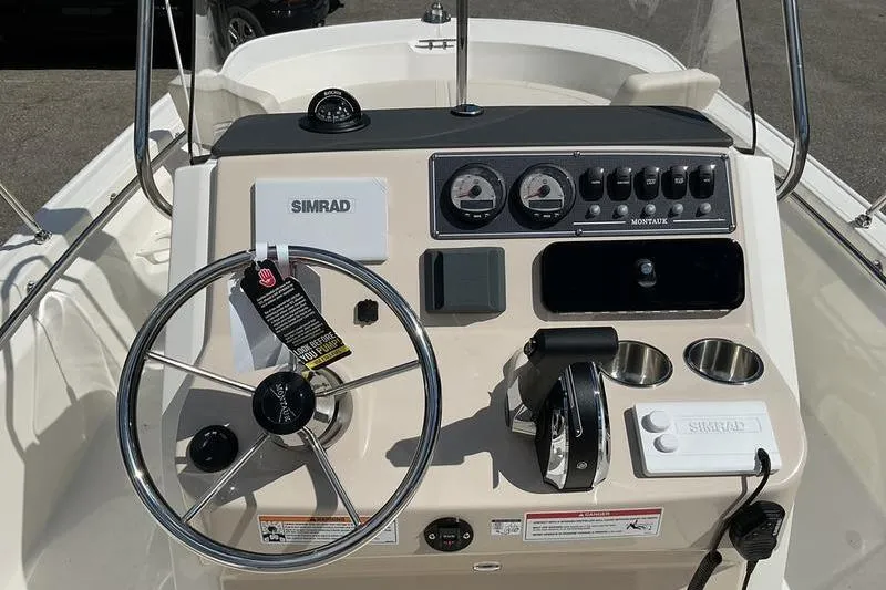 Slide: The Image of 2025 Boston Whaler 210 Montauk boat dashboard with steering wheel and controls. - 8