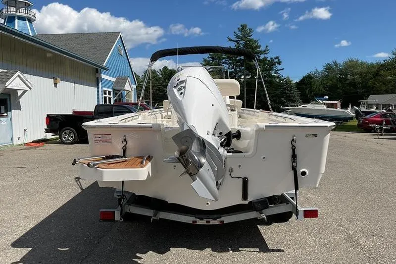 Slide: The Image of 2025 Boston Whaler 210 Montauk boat on trailer, parked outdoors under blue sky. - 9