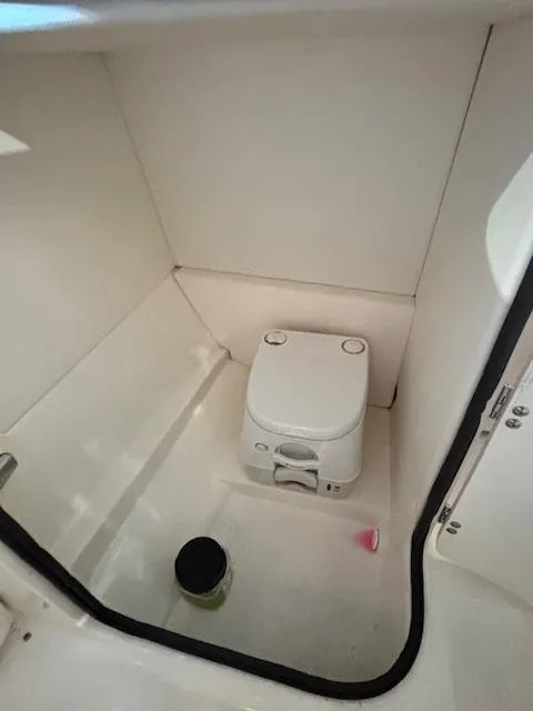 Slide: The Image of 2013 Sea Ray 220 Sundeck interior with compact marine toilet. - 16