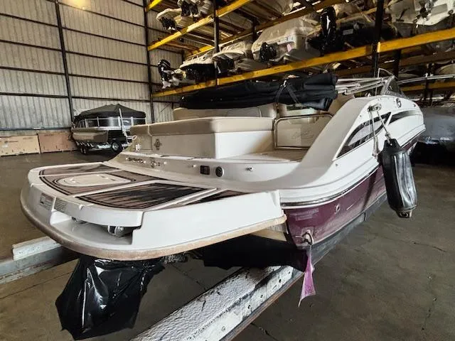 Slide: The Image of 2013 Sea Ray 220 Sundeck boat in storage, showcasing rear deck and seating area. - 4