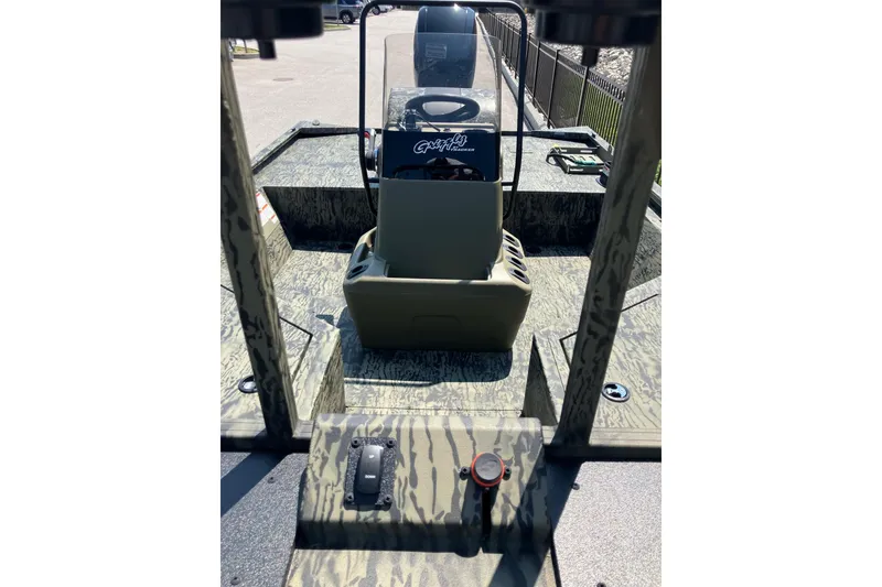 Slide: The Image of 2025 Tracker Grizzly 2072 CC Sportsman boat interior with camouflage design and steering console. - 10