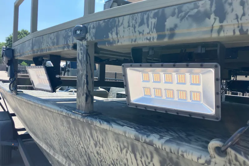Slide: The Image of 2025 Tracker Grizzly 2072 CC Sportsman boat with mounted LED lights, camo design. - 5
