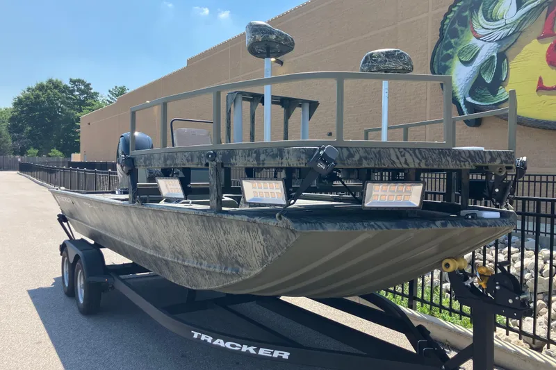 Slide: The Image of 2025 Tracker Grizzly 2072 CC Sportsman boat on trailer, camo design, outdoor setting. - 2