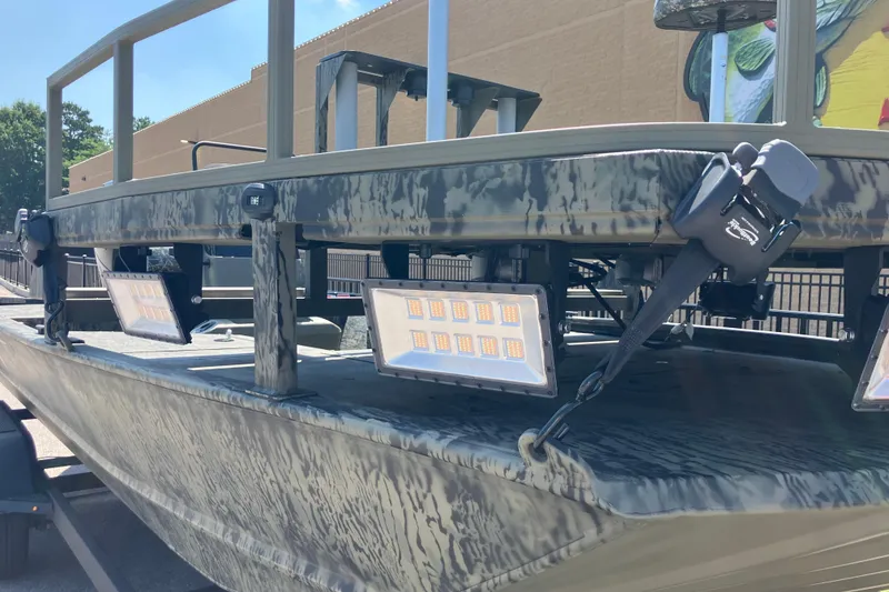 Slide: The Image of 2025 Tracker Grizzly 2072 CC Sportsman boat with mounted LED lights, camo design. - 6