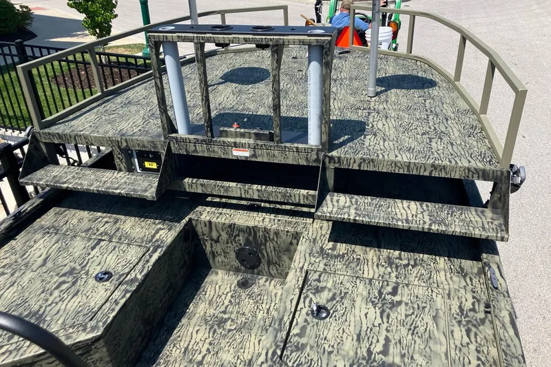 Slide: The Image of 2025 Tracker Grizzly 2072 CC Sportsman boat with camouflage deck design, featuring storage compartments. - 9