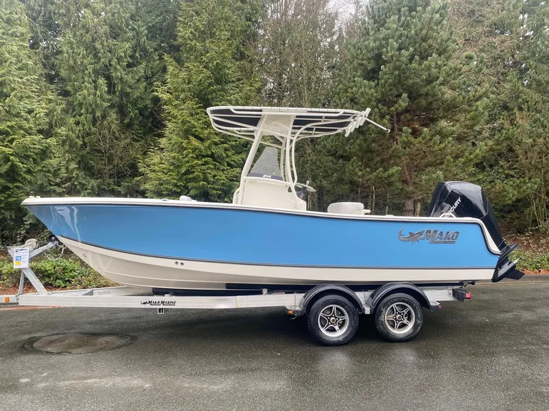 The Image of 2025 Mako 214 CC boat on trailer, blue hull, parked outdoors. - 0