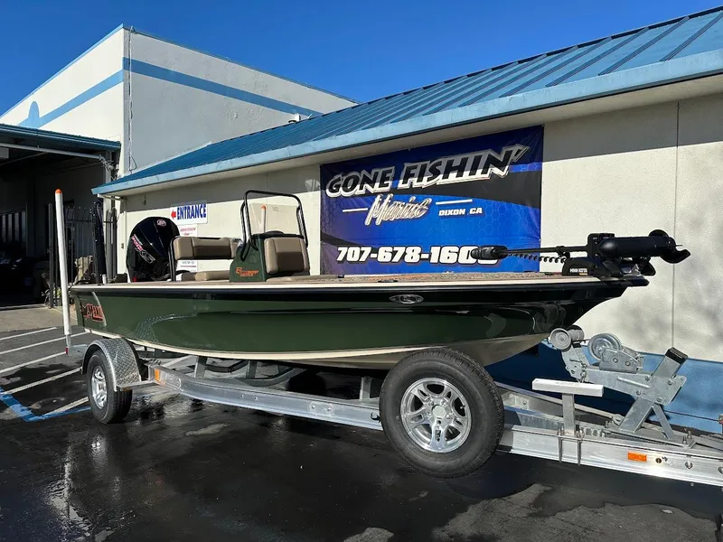 Slide: The Image of 2025 Mako 18 Pro Skiff Backwater Edition boat on trailer outside dealership. - 1