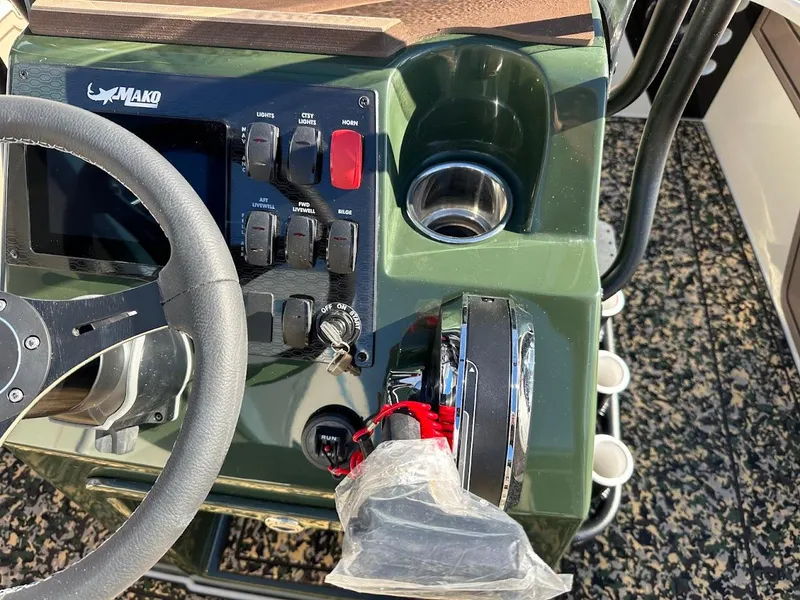 Slide: The Image of Steering console of 2025 Mako 18 Pro Skiff Backwater Edition with controls and cup holder. - 15
