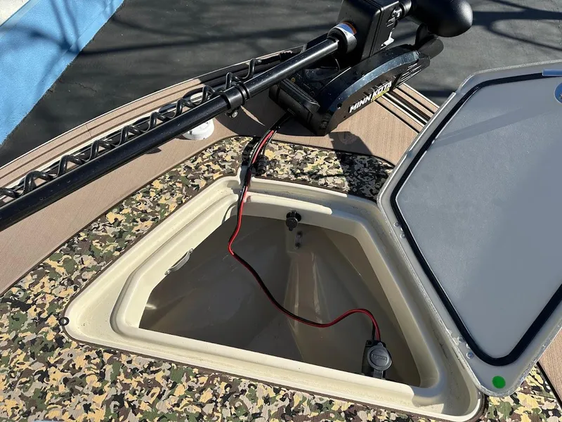 Slide: The Image of 2025 Mako 18 Pro Skiff Backwater Edition with open storage compartment and trolling motor. - 20