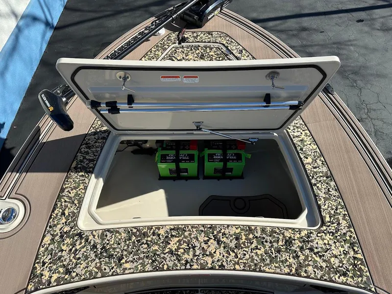 Slide: The Image of 2025 Mako 18 Pro Skiff Backwater Edition with open storage compartment and batteries. - 21