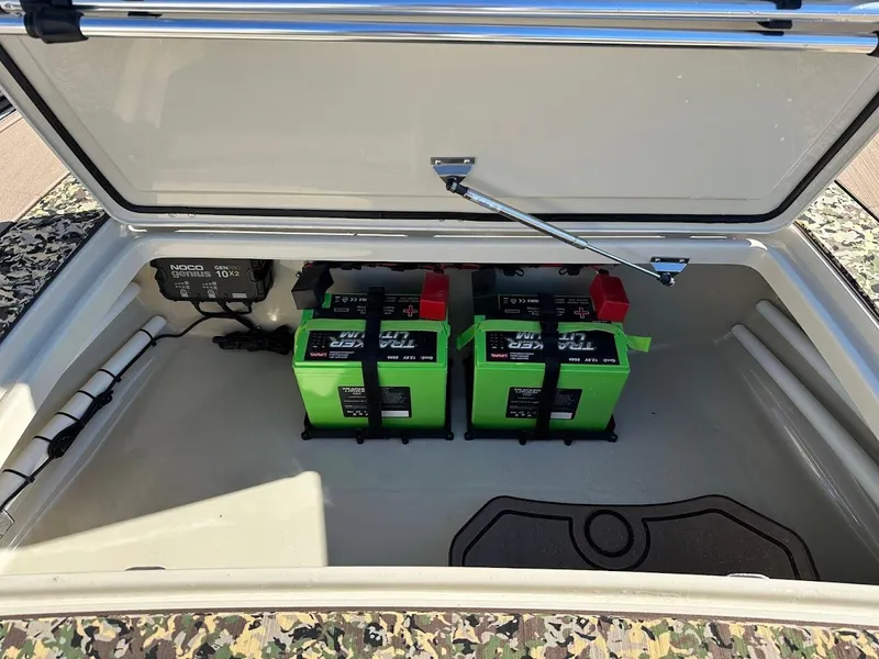Slide: The Image of 2025 Mako 18 Pro Skiff Backwater Edition battery compartment with dual green batteries. - 22