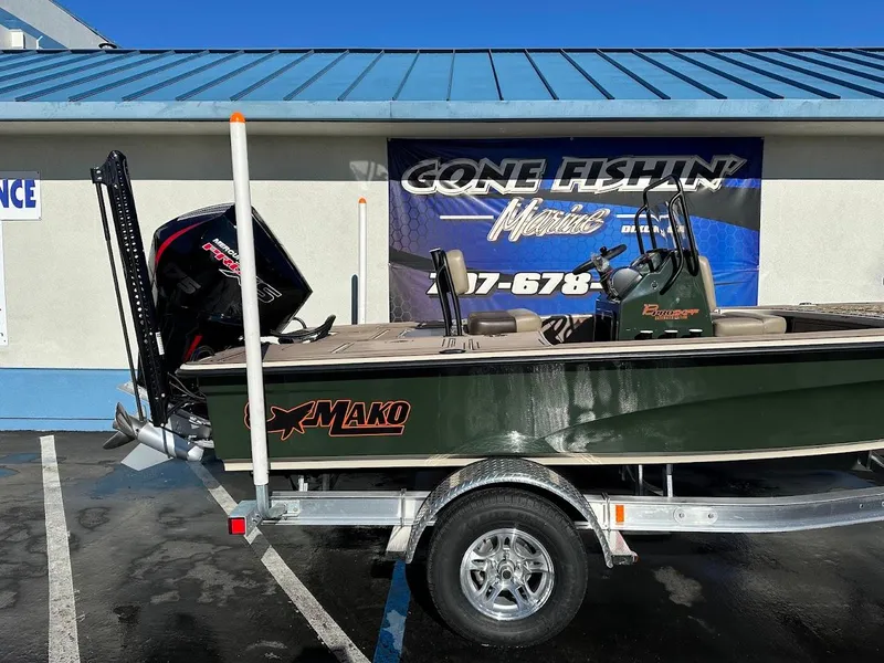 Slide: The Image of 2025 Mako 18 Pro Skiff Backwater Edition on trailer, parked outside a fishing store. - 7