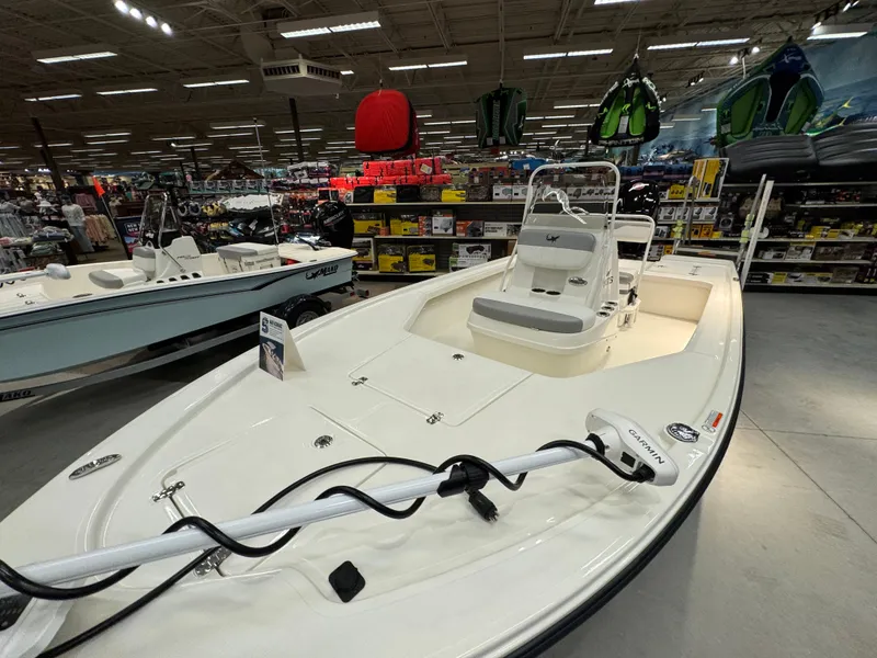 Slide: The Image of 2025 Mako 18 LTS boat displayed in a showroom with various marine equipment. - 2