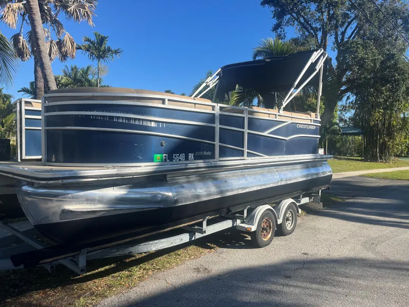 Slide: The Image of 2017 Crestliner 200 RALLY pontoon boat on trailer, parked outdoors. - 1