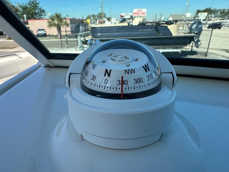 Slide: The Image of Compass on 2023 Sailfish 245 DC boat dashboard, outdoor setting. - 20