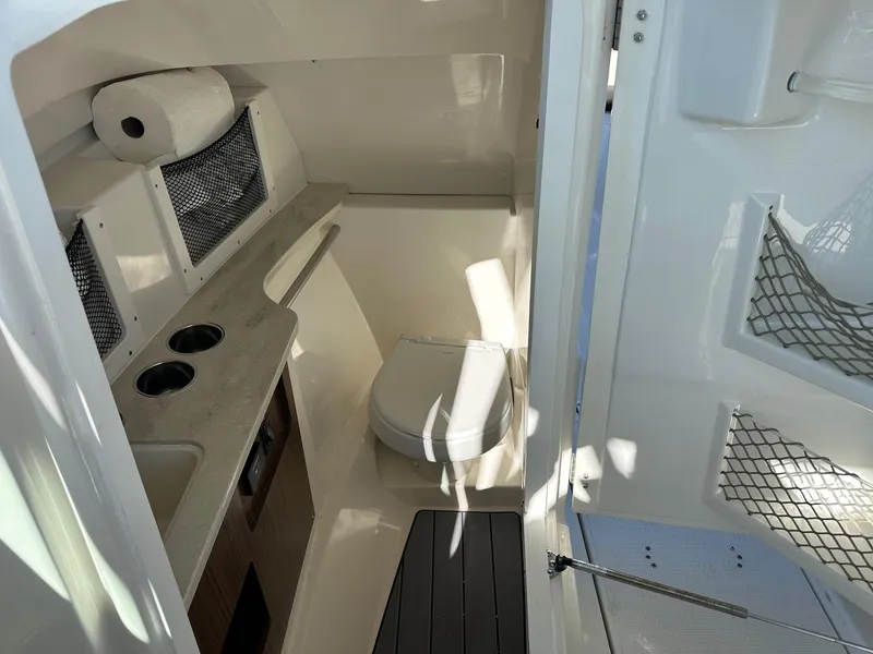 Slide: The Image of 2023 Sailfish 245 DC boat interior with toilet and storage compartments. - 32