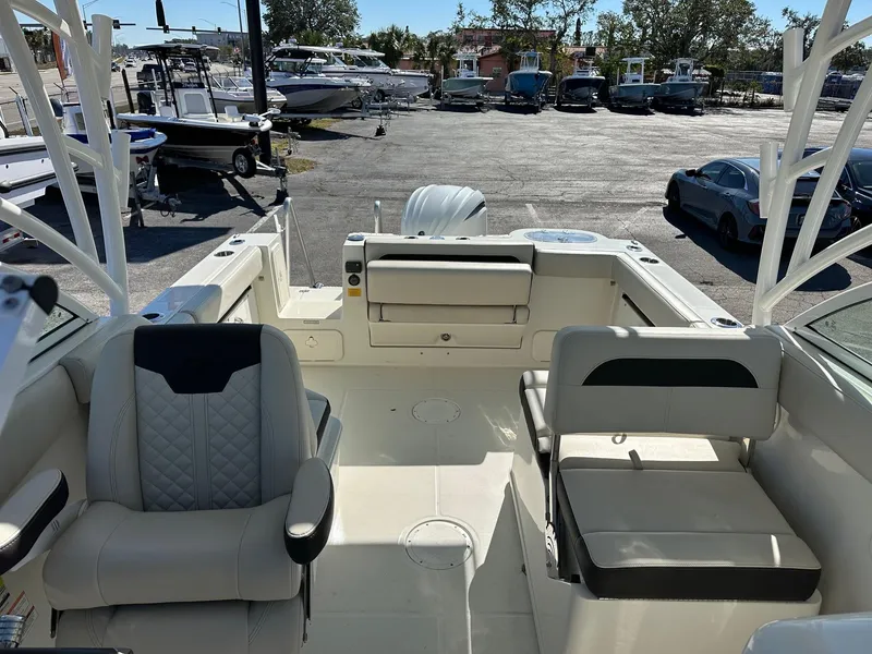 Slide: The Image of 2023 Sailfish 245 DC boat interior with seating and storage, docked at a marina. - 34