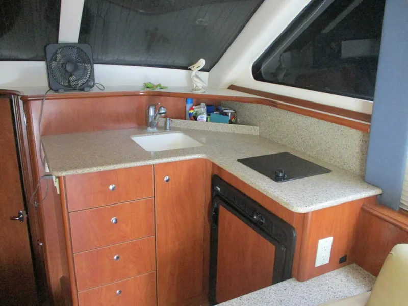 Slide: The Image of 2007 Silverton 33 Convertible yacht kitchen with sink, stove, and storage cabinets. - 37