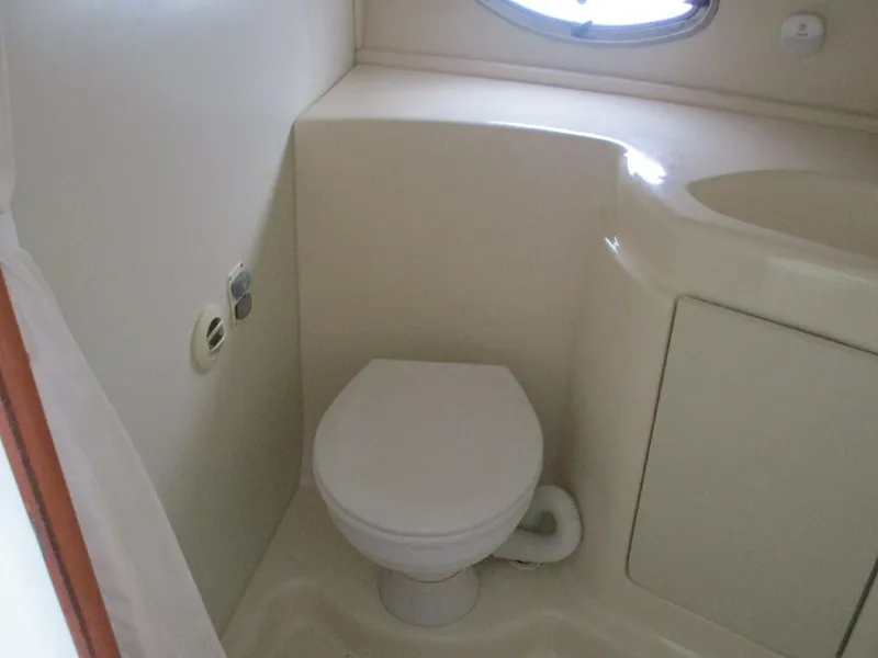 Slide: The Image of 2007 Silverton 33 Convertible boat bathroom with compact toilet and sink. - 45