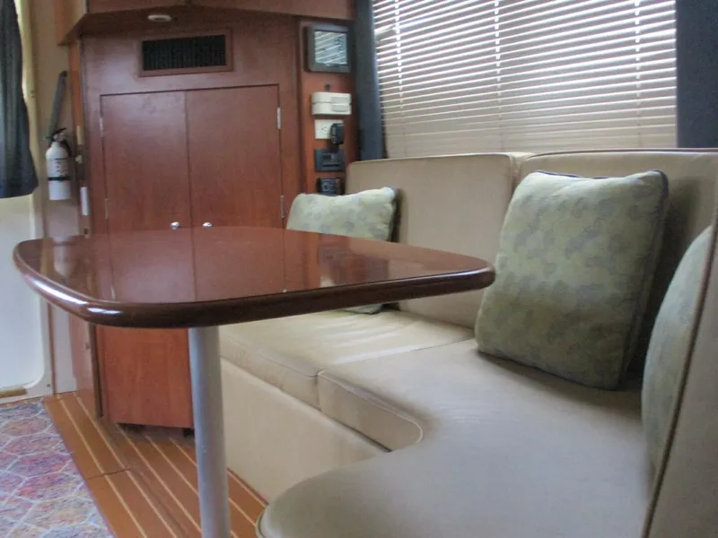 Slide: The Image of Interior of 2007 Silverton 33 Convertible yacht with cushioned seating and wooden table. - 49