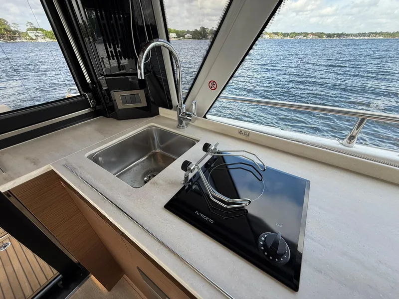 Slide: The Image of Modern kitchen area on 2025 Wellcraft 44 Explorer yacht with sink and stove, overlooking water. - 10