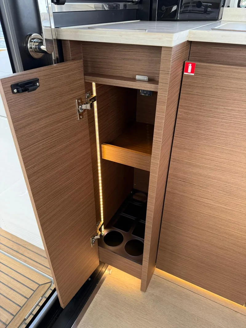 Slide: The Image of 2025 Wellcraft 44 Explorer yacht interior with open wooden cabinet and LED lighting. - 11