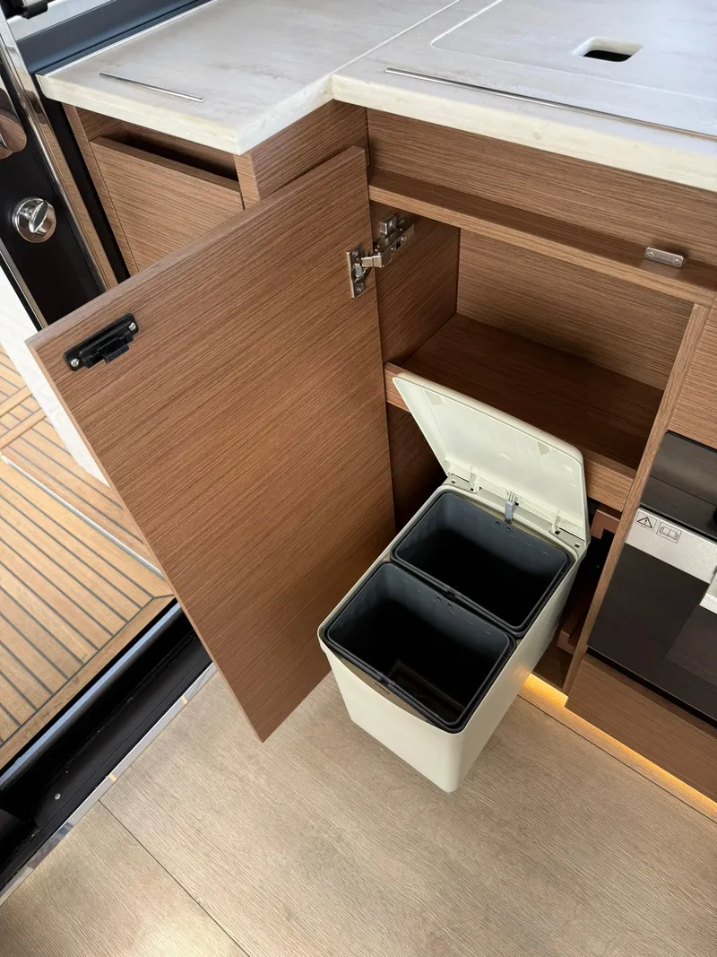 Slide: The Image of 2025 Wellcraft 44 Explorer yacht interior with open cabinet and dual-compartment trash bin. - 13