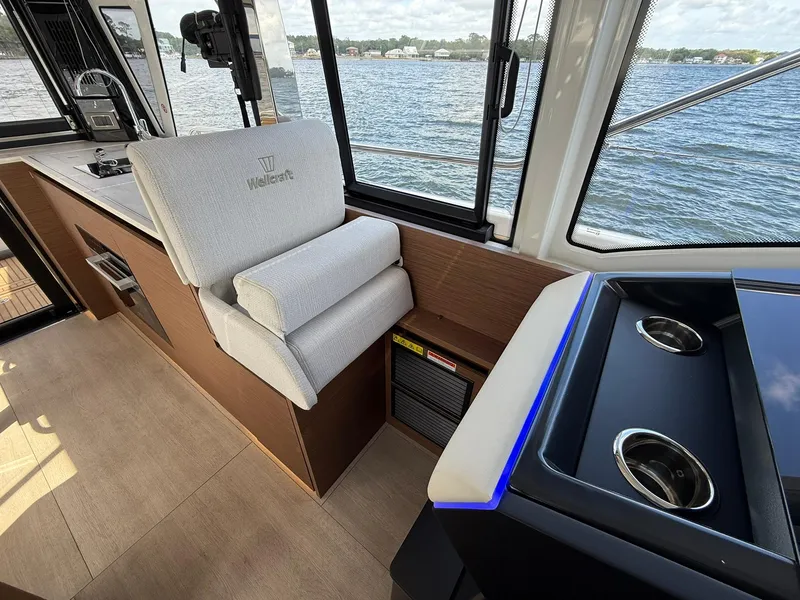 Slide: The Image of Interior of 2025 Wellcraft 44 Explorer boat with seating and cup holders, overlooking water. - 20