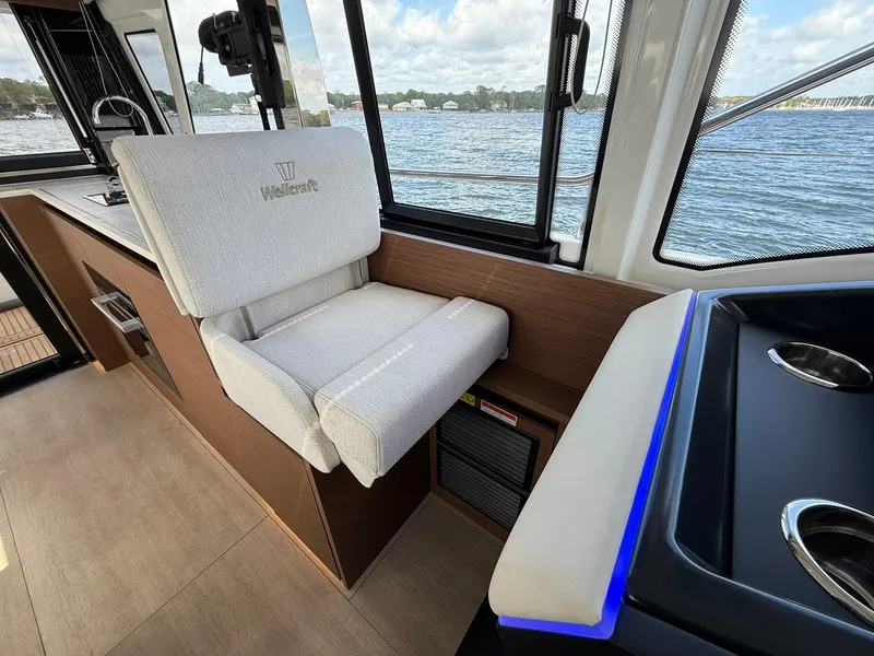 Slide: The Image of 2025 Wellcraft 44 Explorer interior with plush seating and scenic water view. - 21